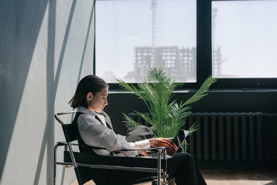 Professional person experiencing eye strain and dryness while working at computer in dry office environment with yellow warning indicators, showing symptoms of digital eye fatigue